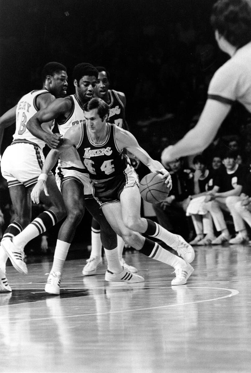 Los Angeles Lakers' Jerry West (44) drives around Milwaukee Bucks' Oscar Robertson and Curtis P ...