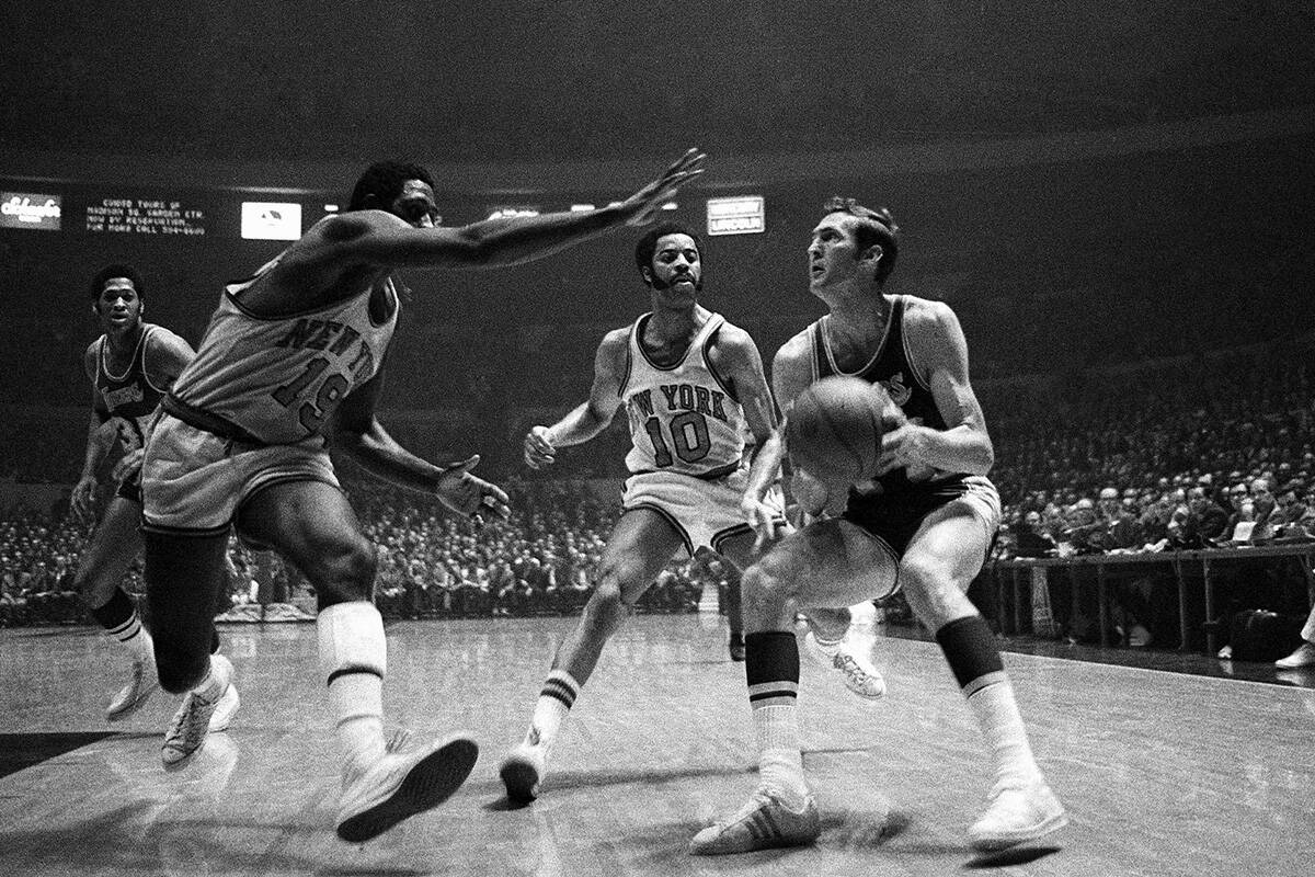 Jerry West of the Los Angeles Lakers crashes against Willis Reed of the New York Knicks as he p ...