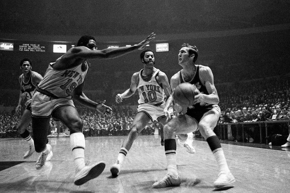 Jerry West of the Los Angeles Lakers crashes against Willis Reed of the New York Knicks as he p ...