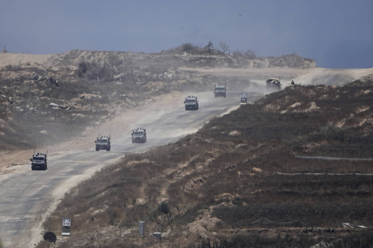 A column of Israeli military vehicles leave the Gaza Strip, as seen from southern Israel, on We ...