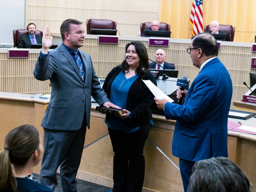 Jim Seebock sworn in as Ward 1 City Councilman by City Clerk Jose Luis Valdez, right, as his wi ...