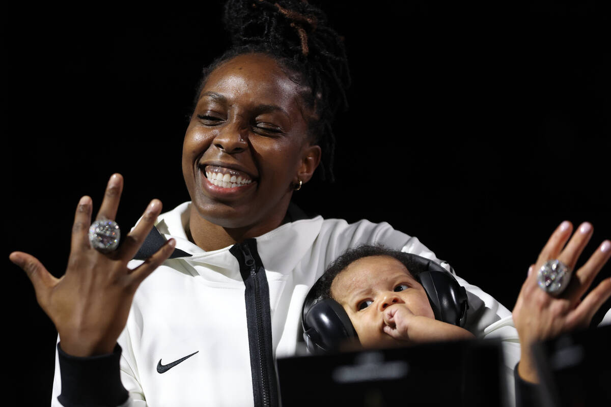 Las Vegas Aces guard Chelsea Gray, holding her son Lennox Gray, poses with her new 2023 WNBA Ch ...