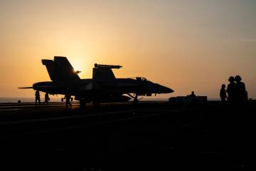 A fighter jet parks on the deck of the USS aircraft carrier Dwight D. Eisenhower, also known as ...