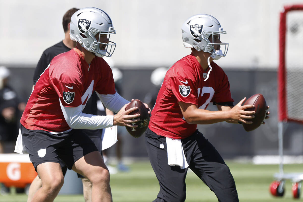 Raiders quarterbacks Carter Bradley (14) and Aidan O'Connell (12) prepare to throw the ball uri ...