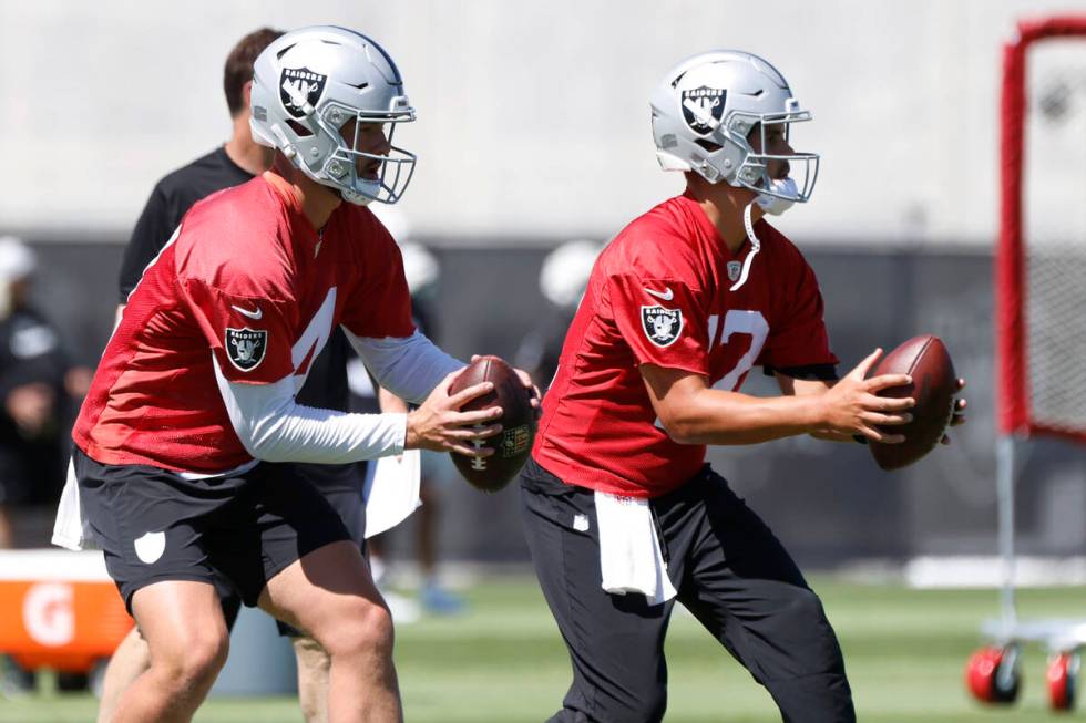 Raiders quarterbacks Carter Bradley (14) and Aidan O'Connell (12) prepare to throw the ball uri ...