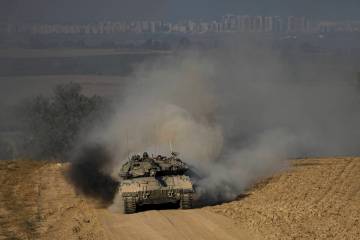 FILE - Israeli soldiers drive a tank near the Israeli-Gaza border, in southern Israel, Wednesda ...