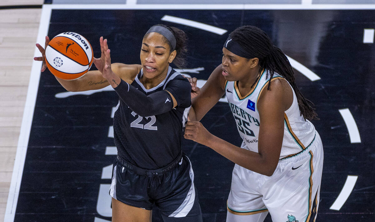 Aces center A'ja Wilson (22) takes a pass with New York Liberty forward Jonquel Jones (35) on h ...