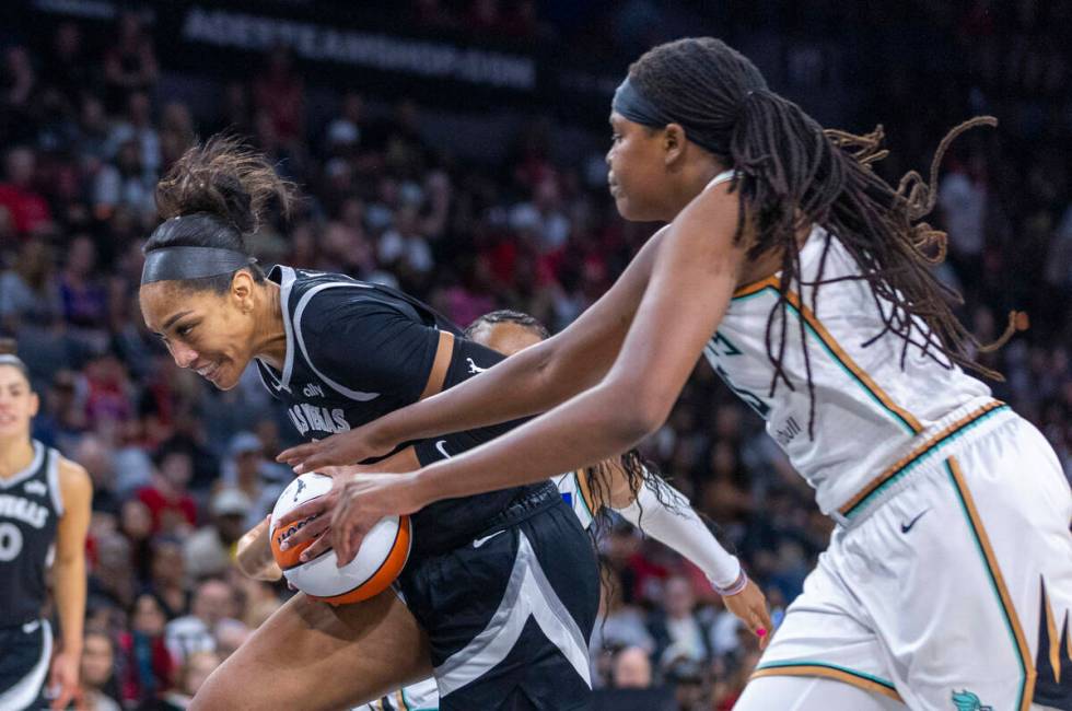 Aces center A'ja Wilson (22) drives as New York Liberty forward Jonquel Jones (35) grabs the ba ...