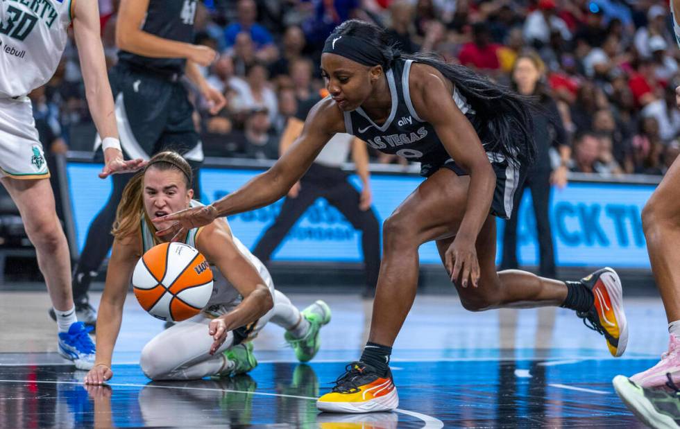 Aces guard Jackie Young (0) reaches for a loose ball as New York Liberty guard Sabrina Ionescu ...