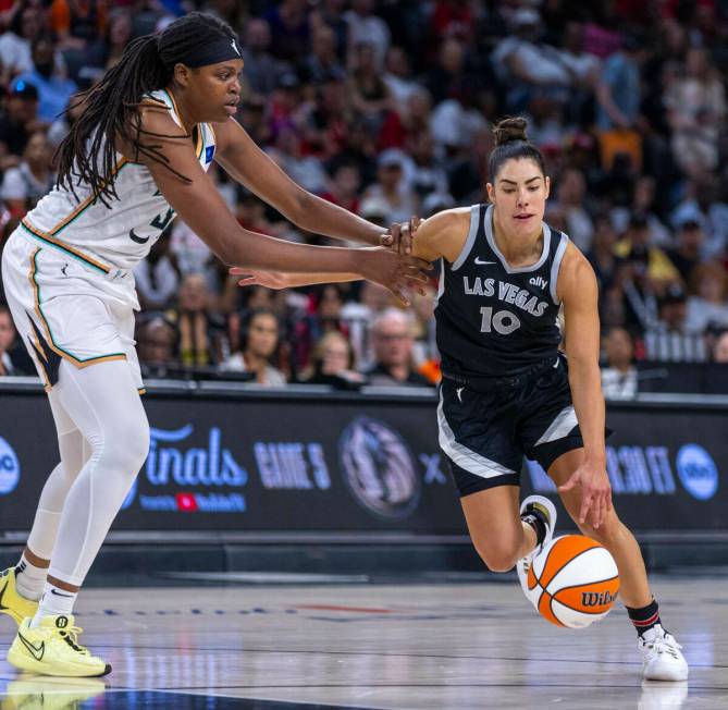 New York Liberty forward Jonquel Jones (35) grabs the arm of Aces guard Kelsey Plum (10) on a d ...