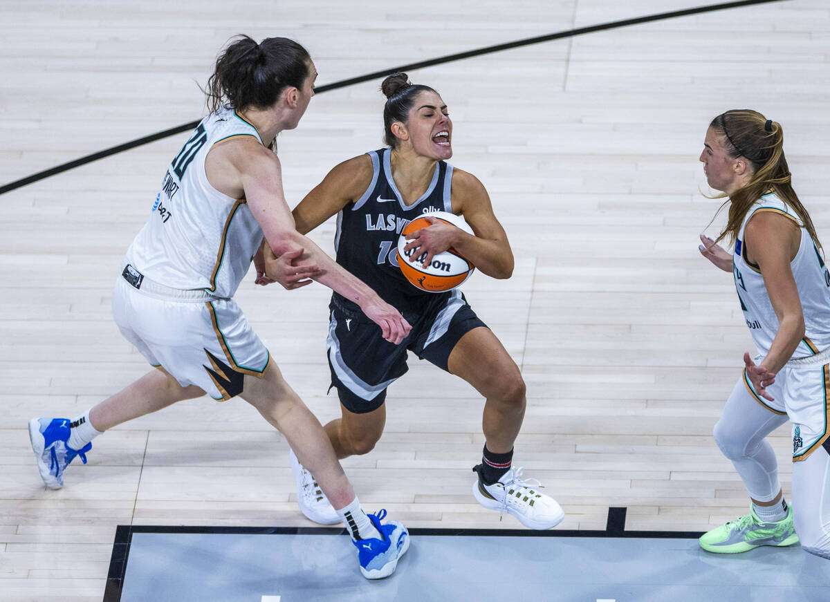 New York Liberty forward Breanna Stewart (30) fights with Aces guard Kelsey Plum (10) as she dr ...