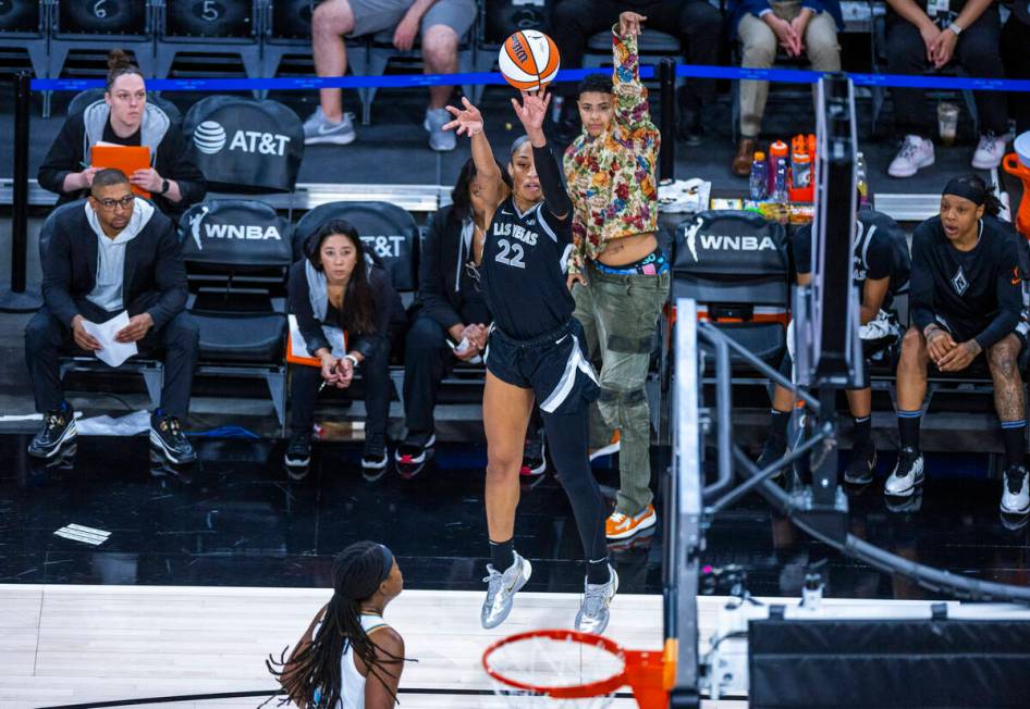 Aces center A'ja Wilson (22) gets off a shot as injured guard Kierstan Bell (1) mirrors her aga ...