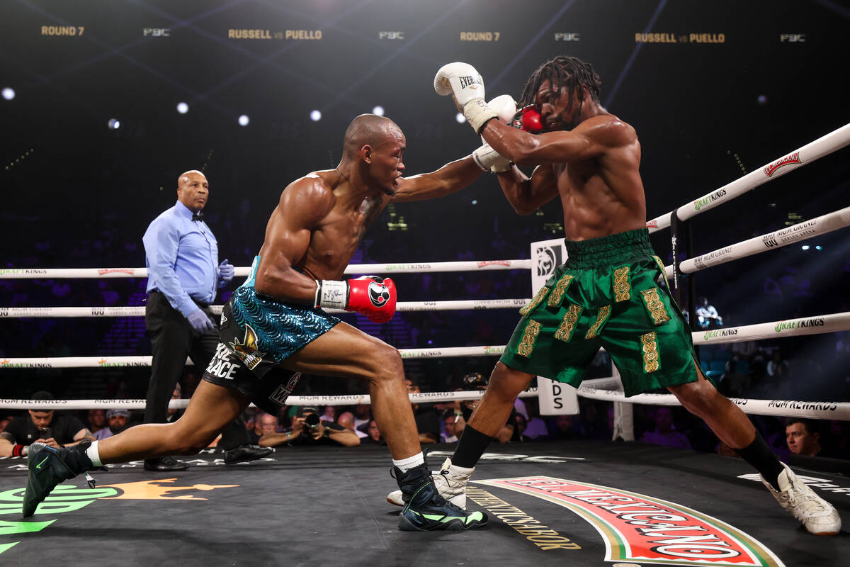 Alberto Puello, left, gets a left on Gary Antuanne Russell during a WBC interim world super lig ...