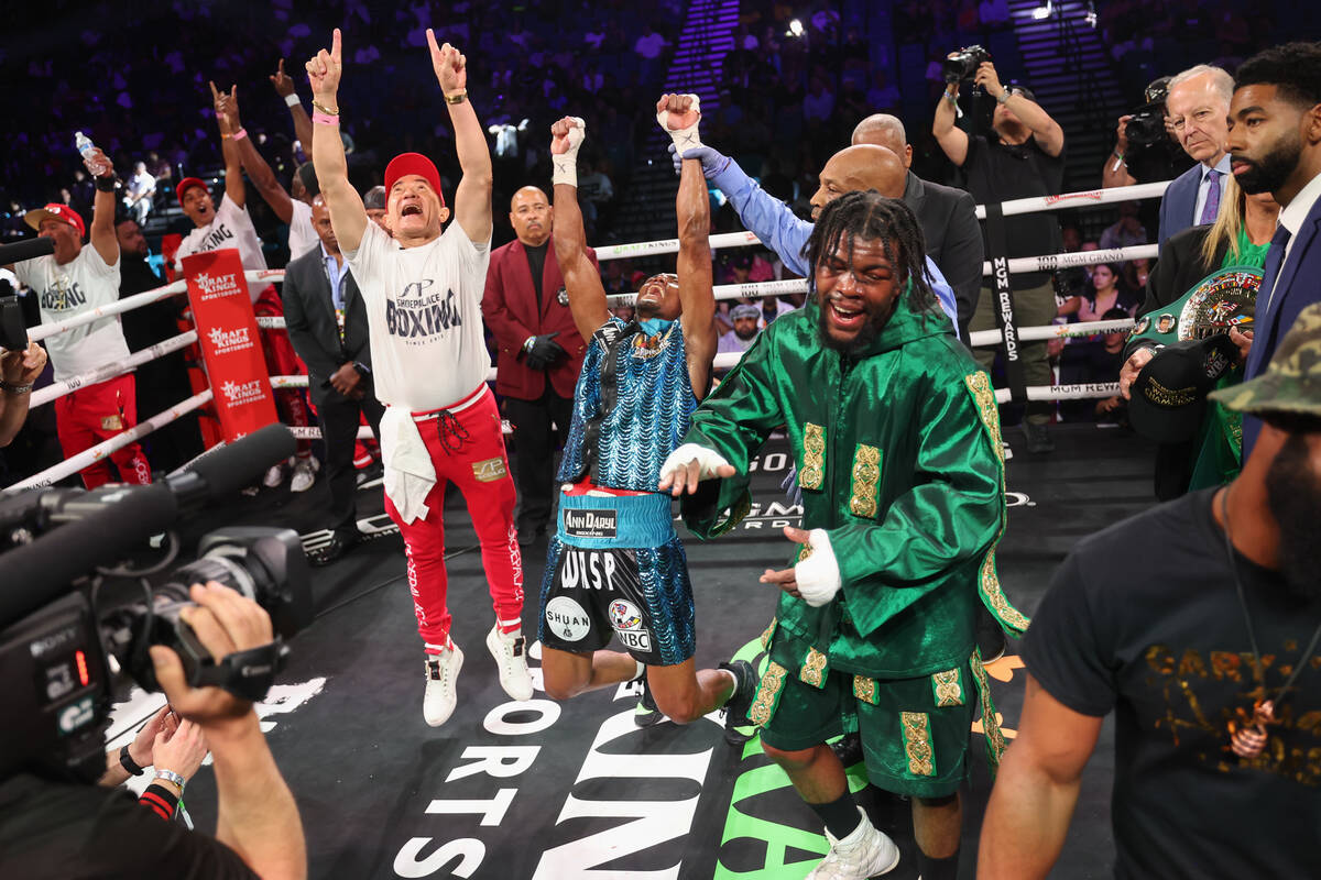 Alberto Puello, center, reacts as he retains his title after facing Gary Antuanne Russell in a ...
