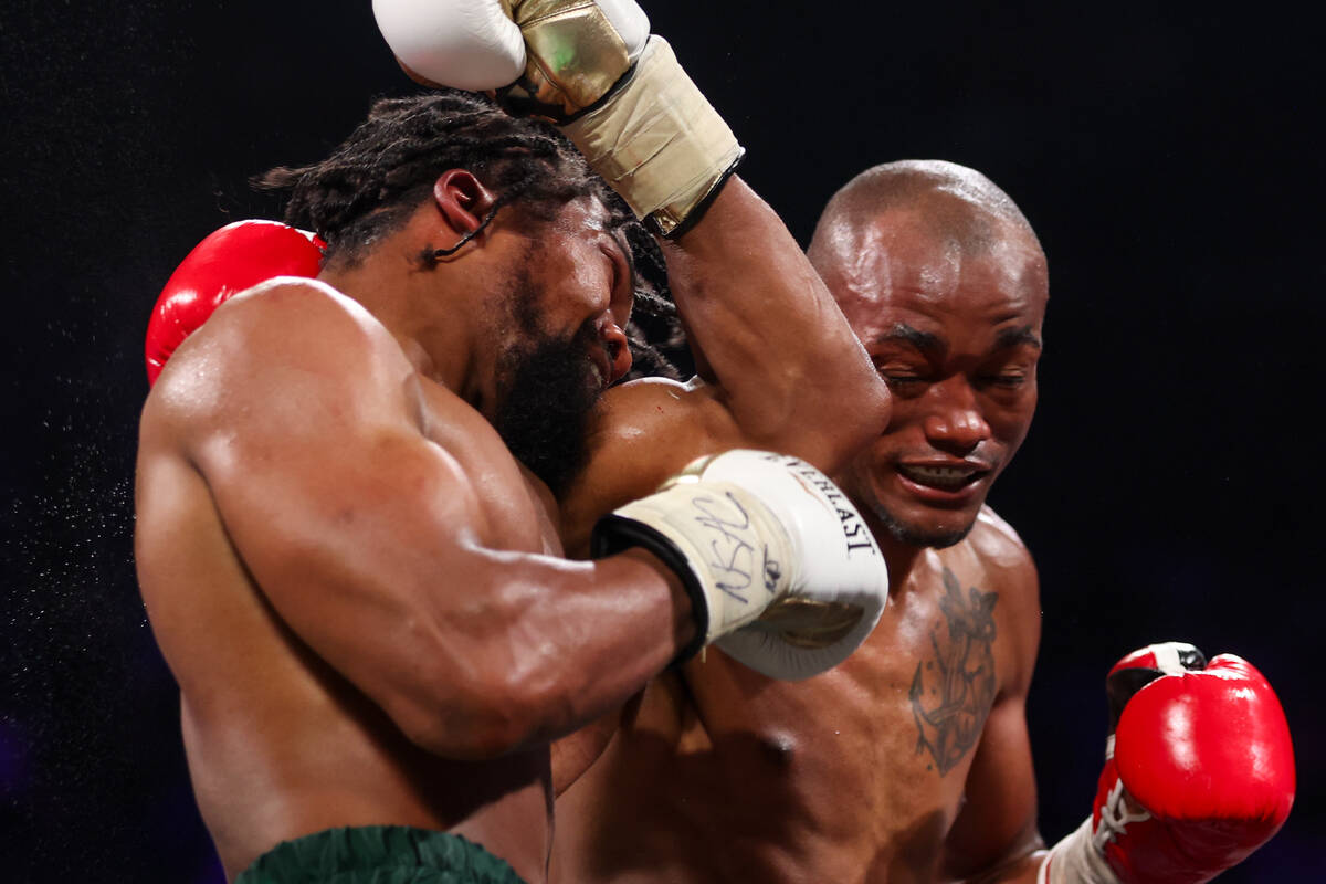 Gary Antuanne Russell, left, takes a hit from Alberto Puello during a WBC interim world super l ...