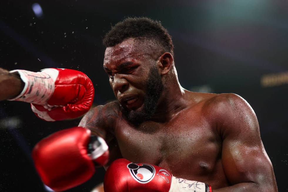 Carlos Adames ducks a punch from Terell Gausha, out of frame at left, during a WBC world middle ...