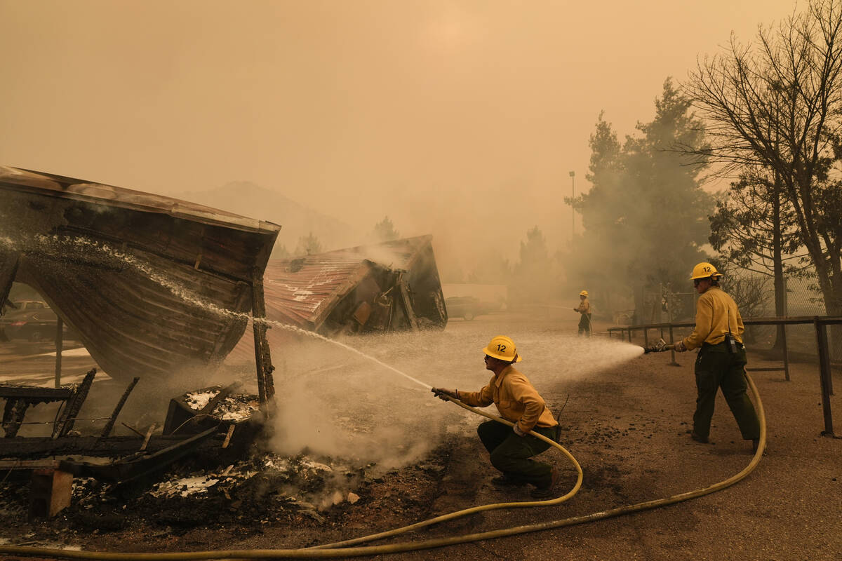 Firefighters hose down a structure at the Los Padres Forest Station while fighting the Post Fir ...