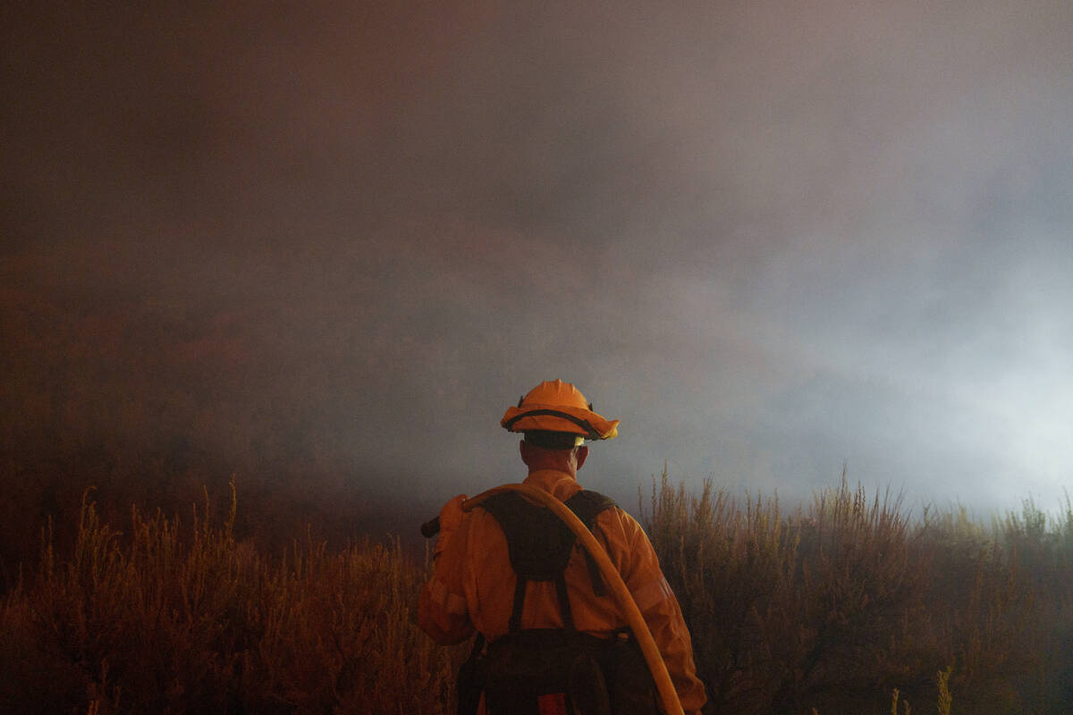 A firefighter watches for flames from the advancing Post Fire on Sunday, June 16, 2024, in Gorm ...