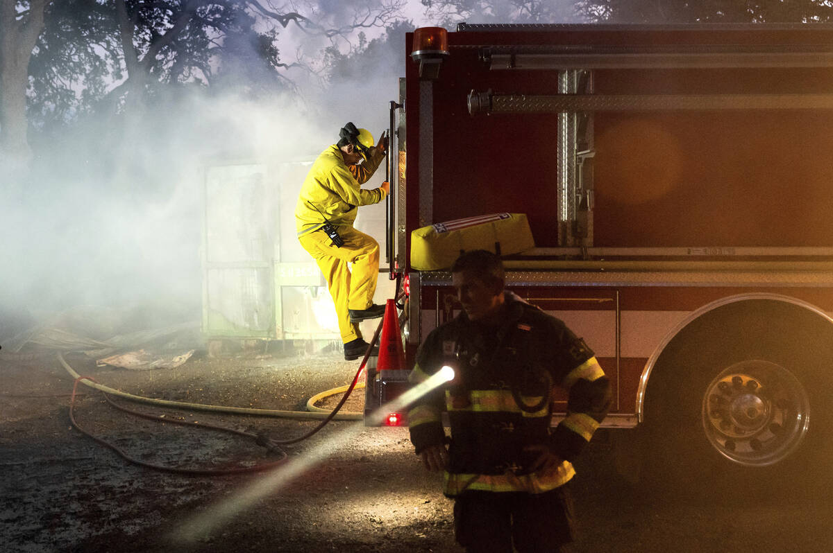 Firefighters battle the Point Fire burning along West Dry Creek Road in Healdsburg, Calif., on ...