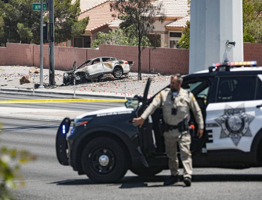 Police at the scene where a woman died in a single car fatal crash near the 215 Beltway in Las ...