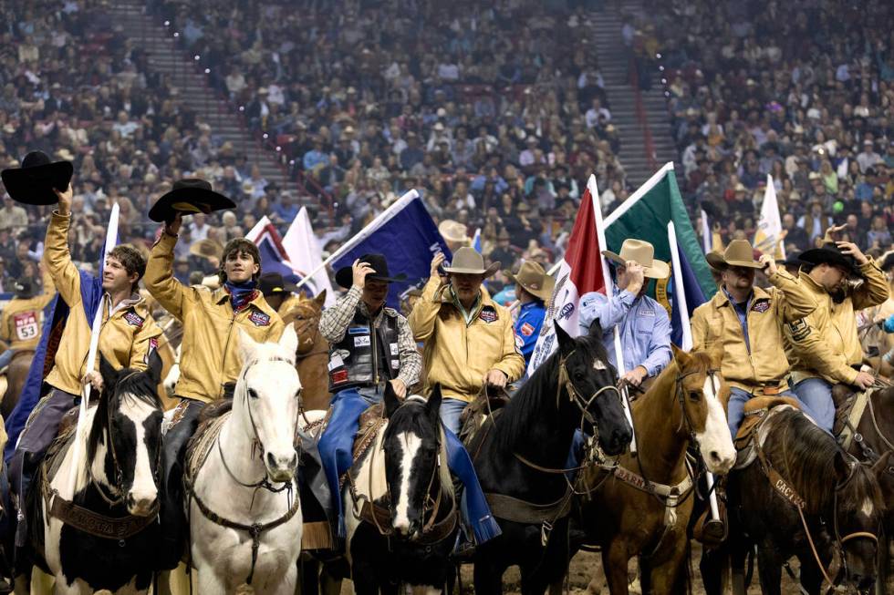 Cowboys salute the crowd with their hats before competing during the sixth go-round of the Nati ...