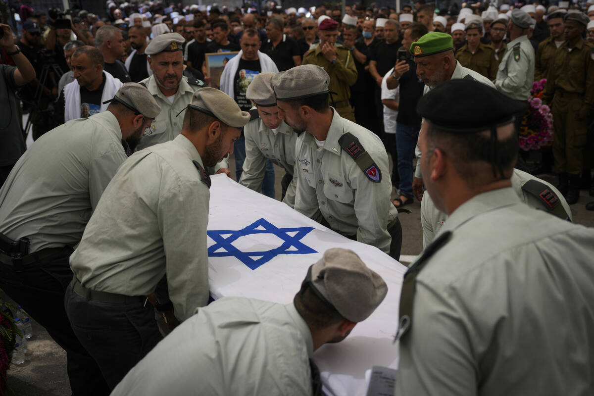 Israeli soldiers carry the flag-draped casket of Capt. Wassem Mahmoud during his funeral in the ...