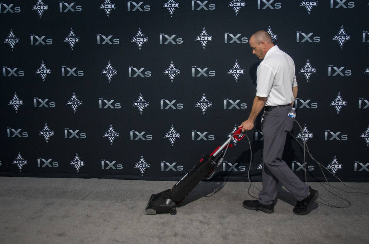 An Allegiant Stadium worker vacuums the silver carpet ahead of The IX Awards ceremony on Monday ...