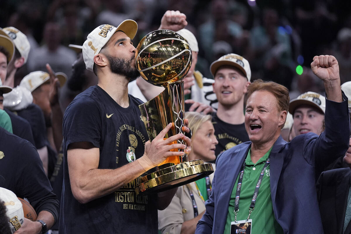 Boston Celtics forward Jayson Tatum kisses the Larry O'Brien Championship Trophy after Game 5 o ...