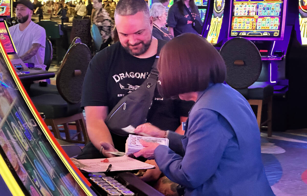 An employee at Bellagio pays out a guest in cash after they win at a slot machine on Saturday, ...