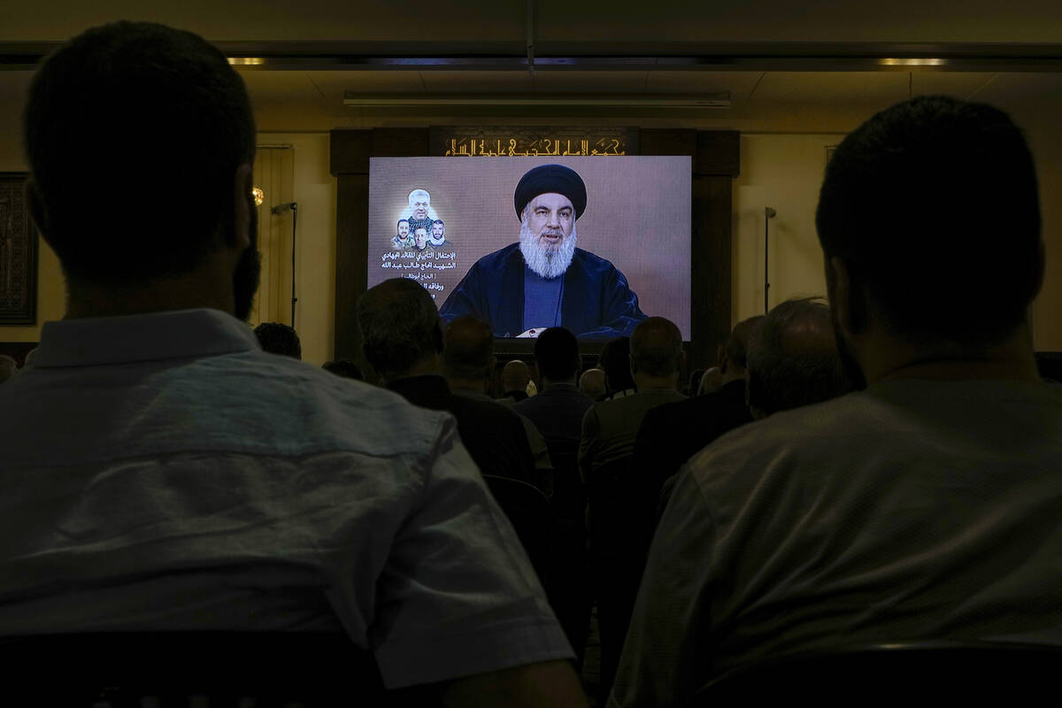 Hezbollah supporters watch a speech given by Hezbollah leader Sayyed Hassan Nasrallah on a scre ...