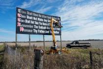 Workers repaint a Ten Commandments billboard off of Interstate 71 on Election Day near Chenowet ...