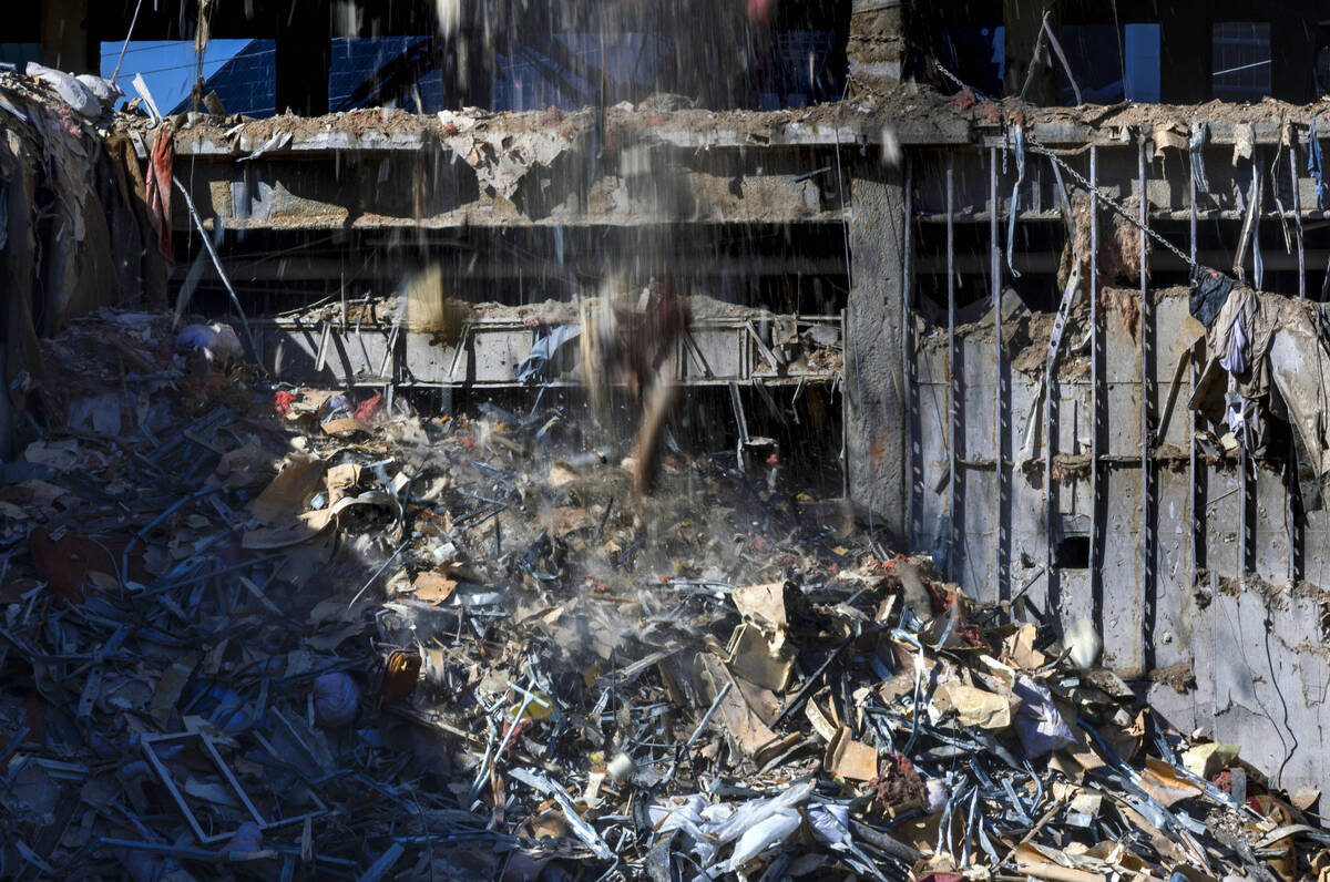 Debris lands on a growing pile pushed out of a floor above near the former entrance as demoliti ...