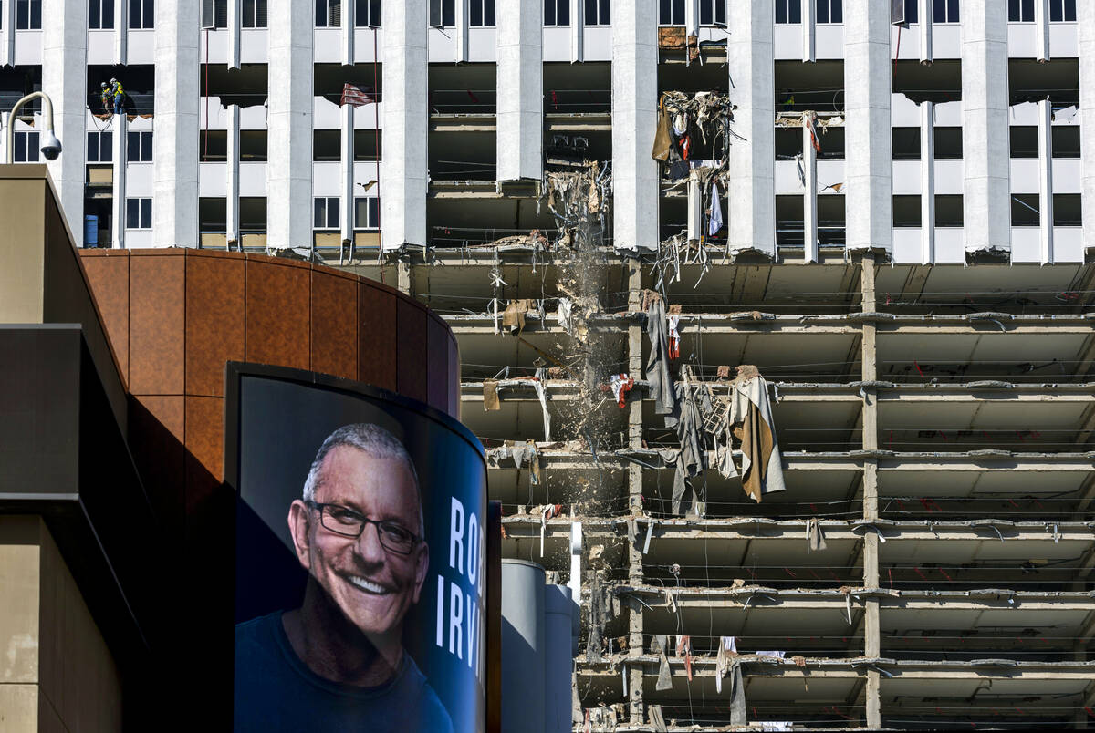 An old ad for Robert Irvine's Public House remains on the exterior as debris is pushed out of a ...