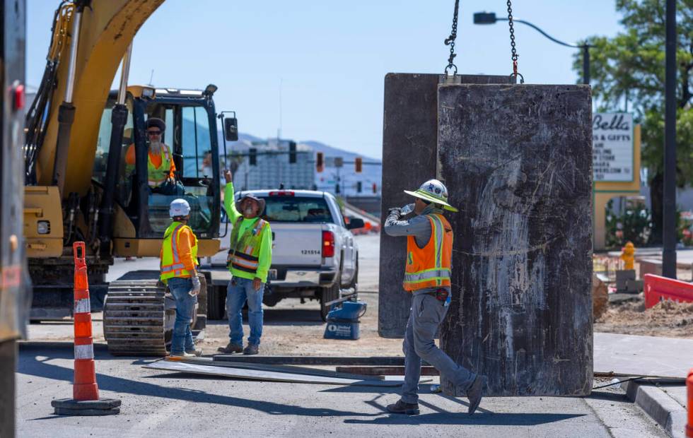 A construction worker drinks water on a road project along West Charleston Blvd. as he and othe ...