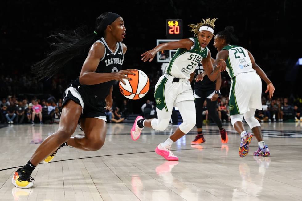 Las Vegas Aces guard Jackie Young (0) drives toward the hoop while Seattle Storm guard Jordan H ...