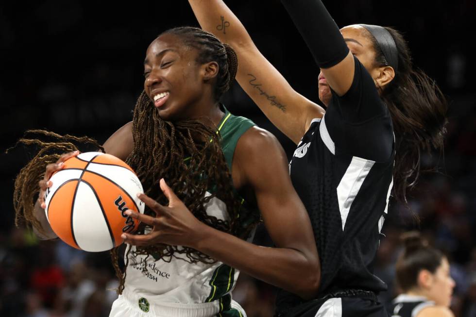 Seattle Storm center Ezi Magbegor, left, drives toward the hoop while Las Vegas Aces center A'j ...