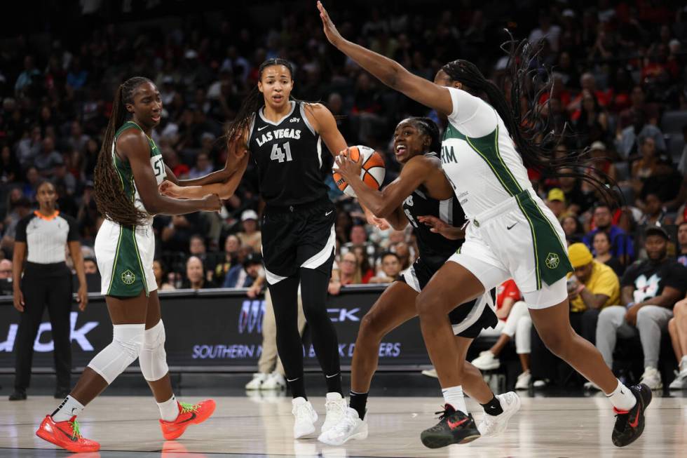 Las Vegas Aces guard Tiffany Hayes, center right, shoots against Seattle Storm forward Joyner H ...