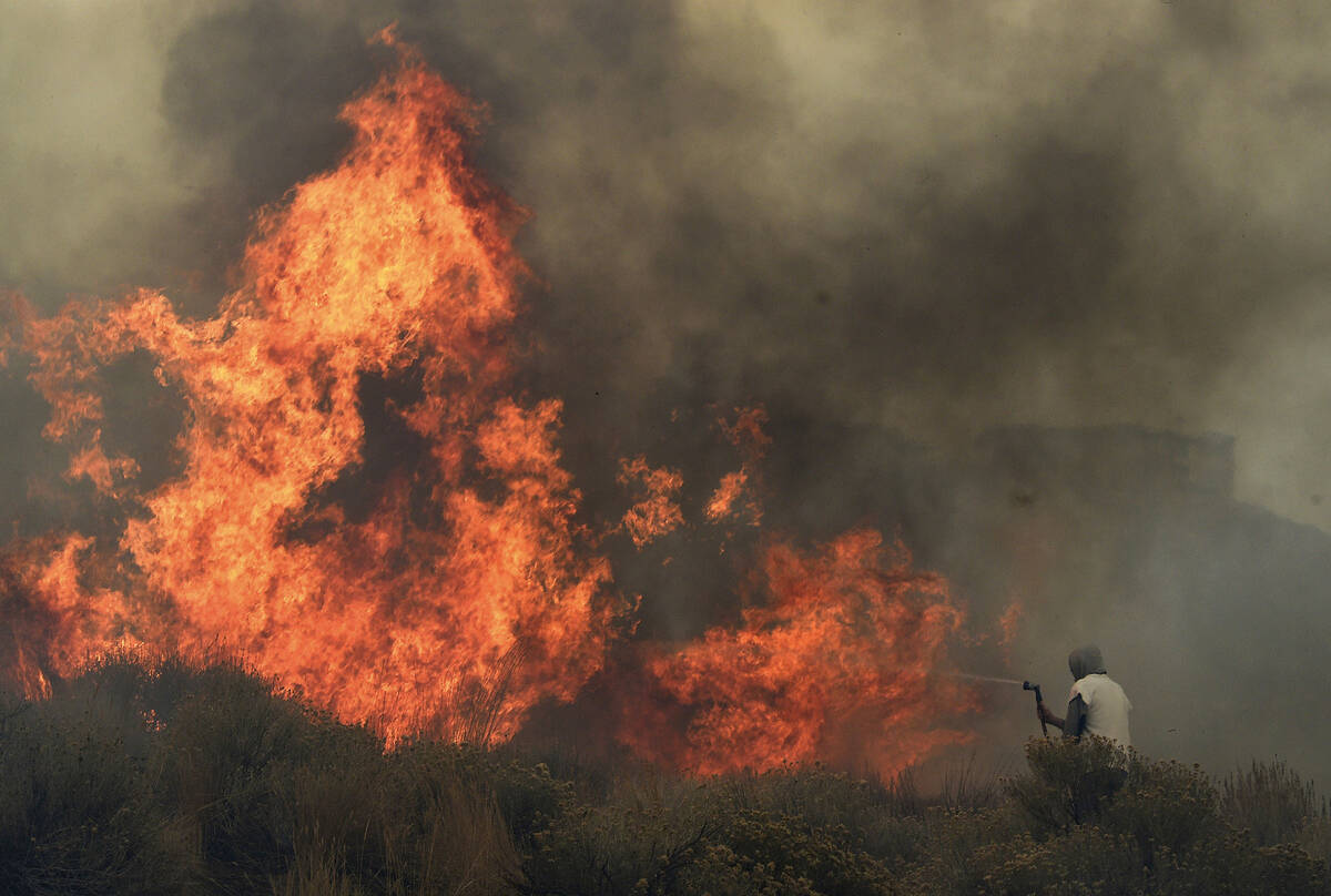 Homeowner Steven Phelps battles the Pinehaven Fire in the Caughlin Ranch area of Reno on Nov. 1 ...