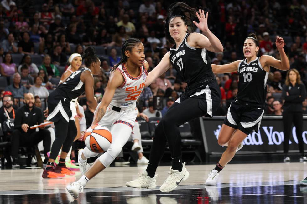 Connecticut Sun guard Tyasha Harris (52) dribbles around Las Vegas Aces center Megan Gustafson ...