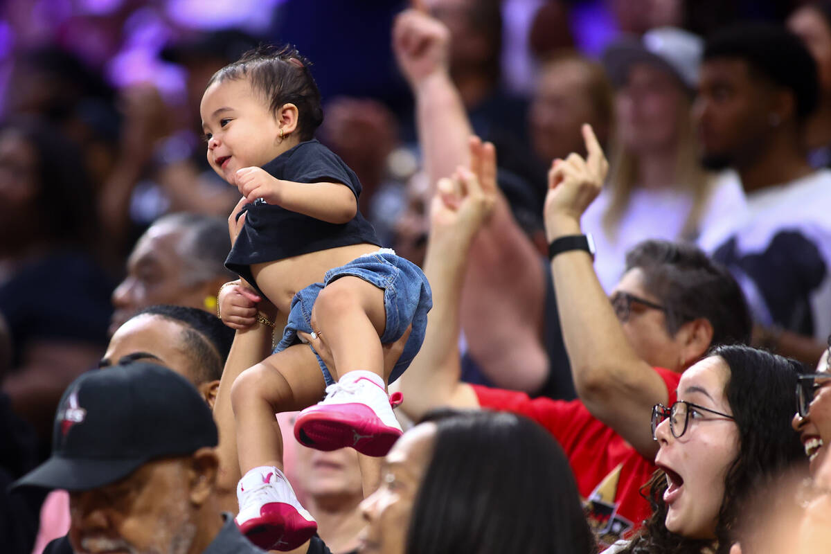 A young Las Vegas Aces fan is hoisted above the crowd as the Aces are winning during the second ...