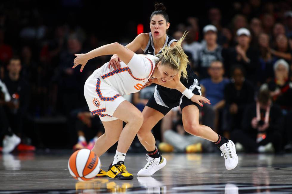 Connecticut Sun guard Rachel Banham, left, and Las Vegas Aces guard Kelsey Plum, behind, strugg ...