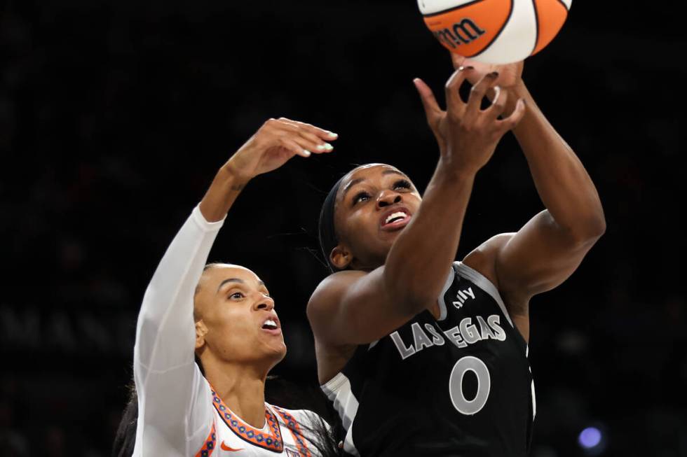 Las Vegas Aces guard Jackie Young (0) jumps for a rebound against Connecticut Sun forward DeWan ...