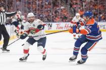 Florida Panthers' Sam Reinhart (13) and Edmonton Oilers' Brett Kulak (27) compete for the puck ...