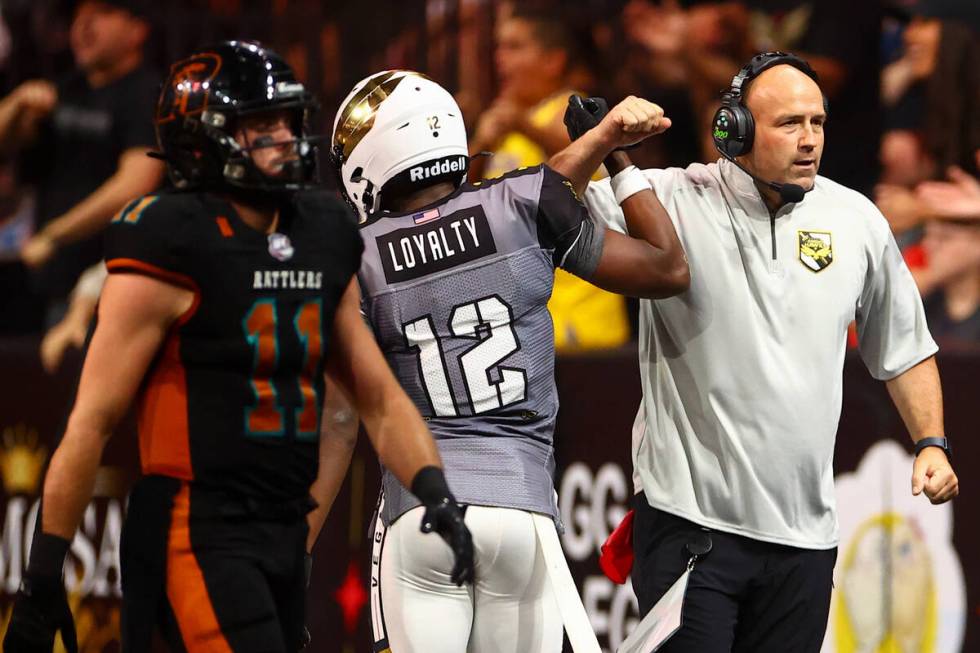 Vegas Knight Hawks head coach Mike Davis, right, congratulates defensive back James Ceasar (12) ...