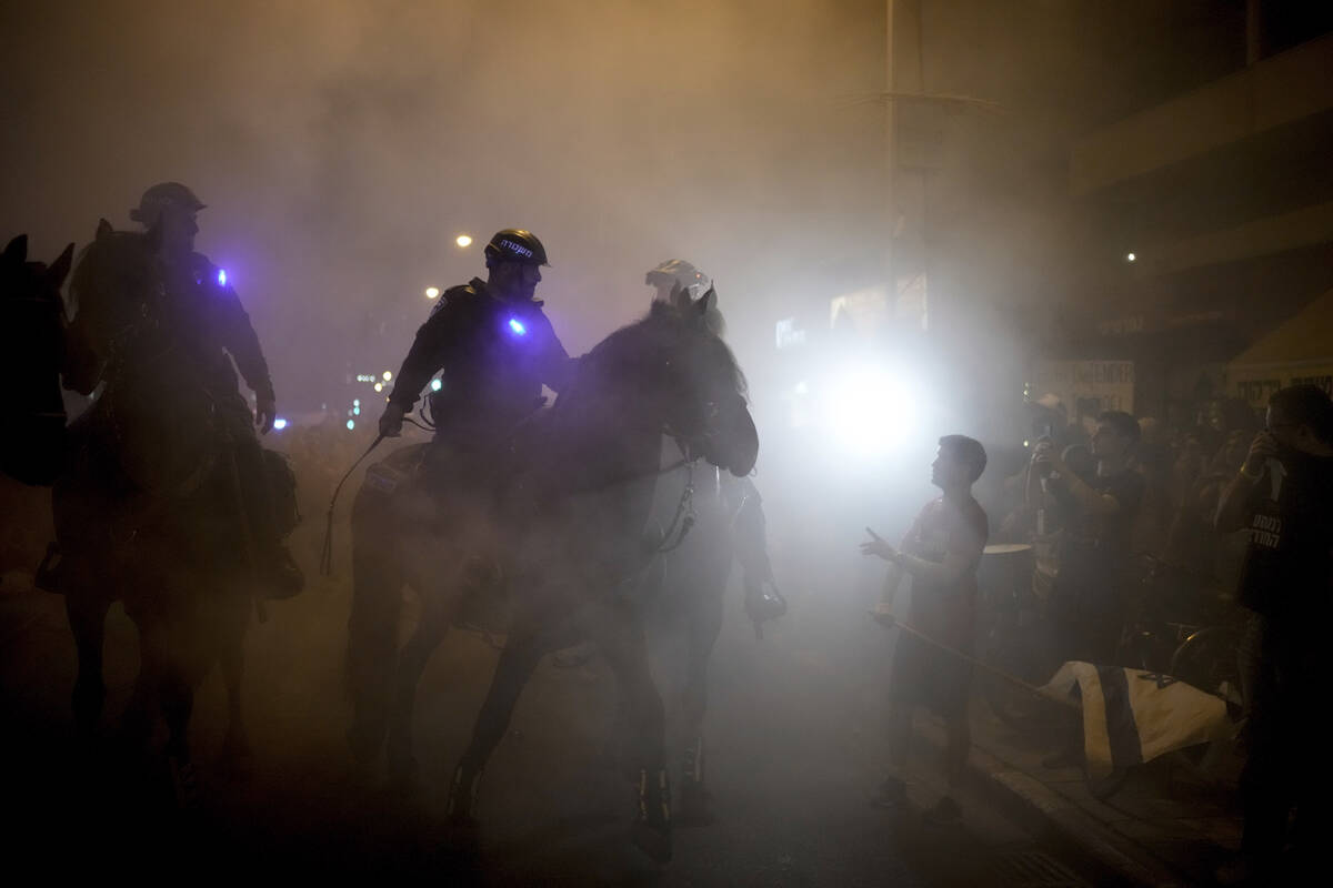 Israeli mounted police officers disperse demonstrators blocking a road during a protest against ...