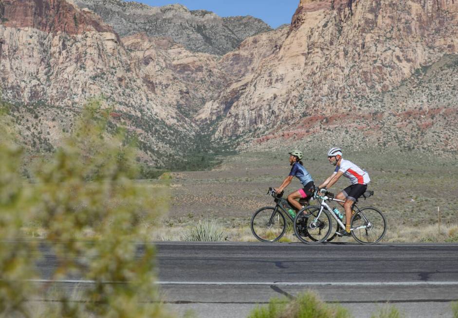 Li Jiang, left, and Steve Iseman, right, ride on Red Rock Canyon Road in Las Vegas, Sunday, Jun ...