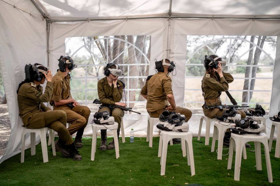 Israeli soldiers watch a virtual tour of the destruction of the aftermath of the Oct. 7 Hamas a ...