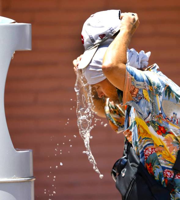 Buddy Willer of Las Vegas uses water from a water refilling station to cool himself at Lorenzi ...