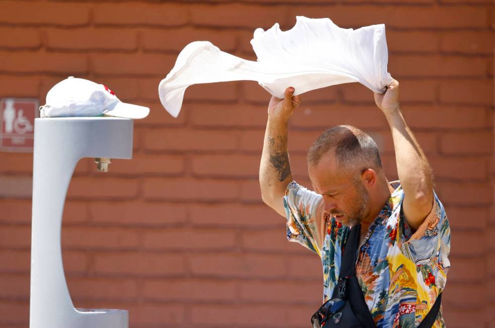 Buddy Willer of Las Vegas uses a wet towel to cool himself at Lorenzi Park on a sunny and hot M ...