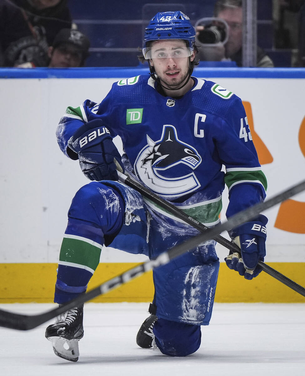 Vancouver Canucks' Quinn Hughes pauses after being checked to the ice during the third period o ...